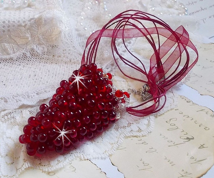 Pendentif Tendre Rouge mont&eacute; avec des gouttes en verre rouge, des perles rondes facett&eacute;es et des perles nacr&eacute;es