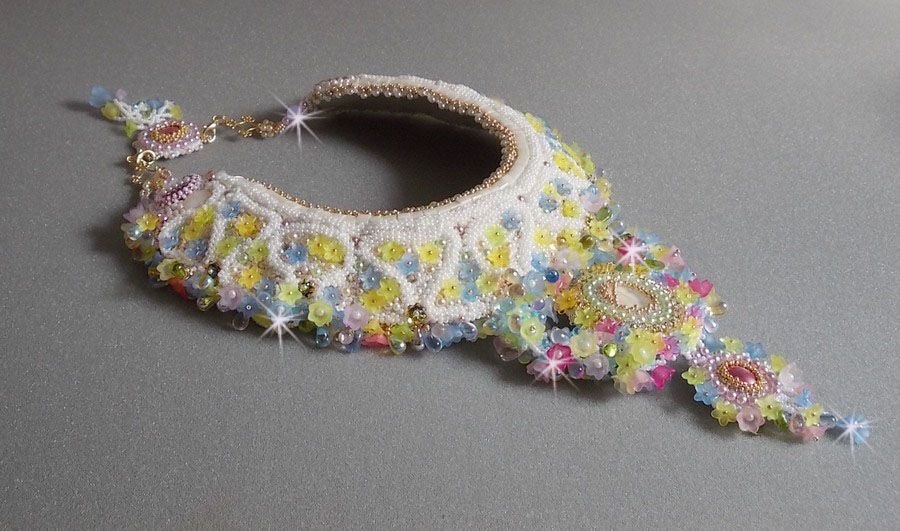 Plastron Envol&eacute;e Fleurie Haute Couture brod&eacute; avec des cabochons Nacre et R&eacute;sine aux couleurs Fuchsia et Ivoire, s&rsquo;ajoute des fleurs lucites, feuilles en verre, chatons et perles en Cristal.