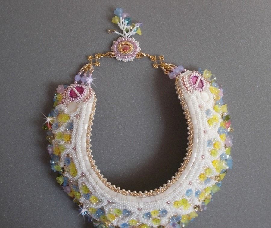 Plastron Envol&eacute;e Fleurie Haute Couture brod&eacute; avec des cabochons Nacre et R&eacute;sine aux couleurs Fuchsia et Ivoire, s&rsquo;ajoute des fleurs lucites, feuilles en verre, chatons et perles en Cristal.
