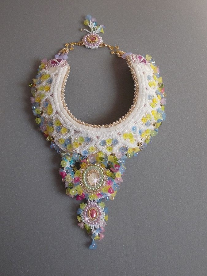 Plastron Envol&eacute;e Fleurie Haute Couture brod&eacute; avec des cabochons Nacre et R&eacute;sine aux couleurs Fuchsia et Ivoire, s&rsquo;ajoute des fleurs lucites, feuilles en verre, chatons et perles en Cristal.