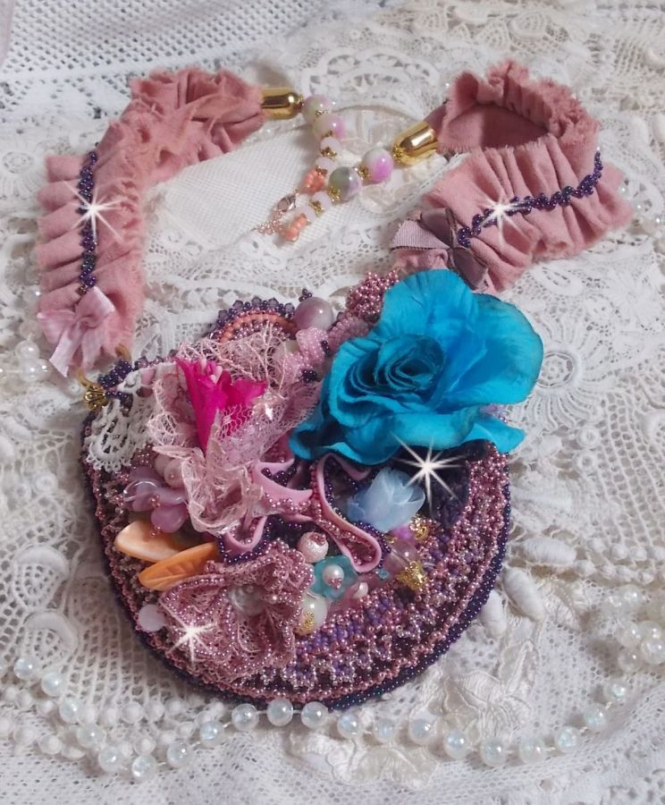 Plastron artisanal romantique en dentelle, perles et fleurs colorées.