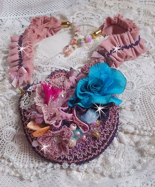 Plastron artisanal romantique en dentelle, perles et fleurs colorées.