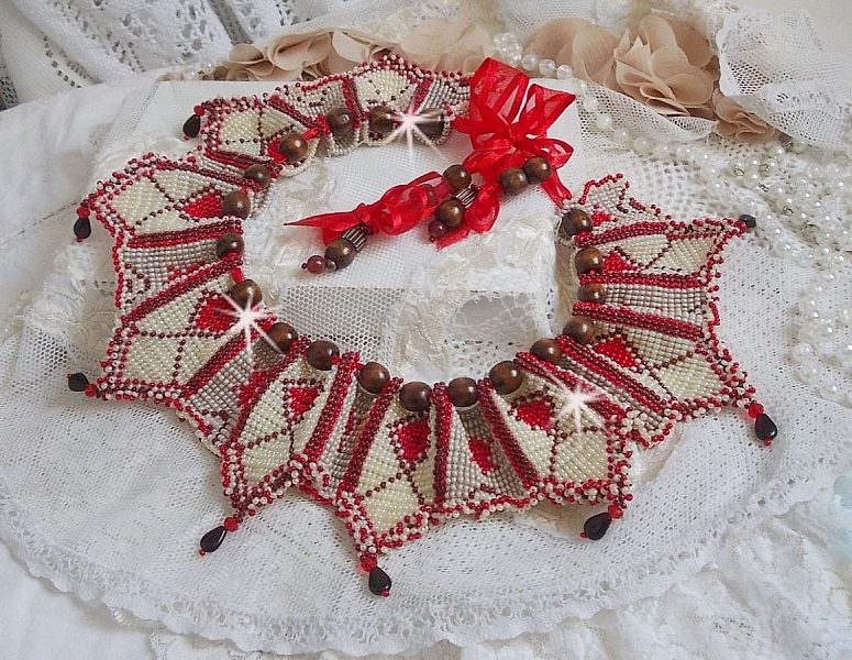 Collier Romane plastron mont&eacute; avec une abondance de rocailles aux couleurs : Bordeaux, Ivoire et Rouge &agrave; laquelle s'ajoute des gouttes plates, perles en bois, perles en laiton pour un style Ethnique