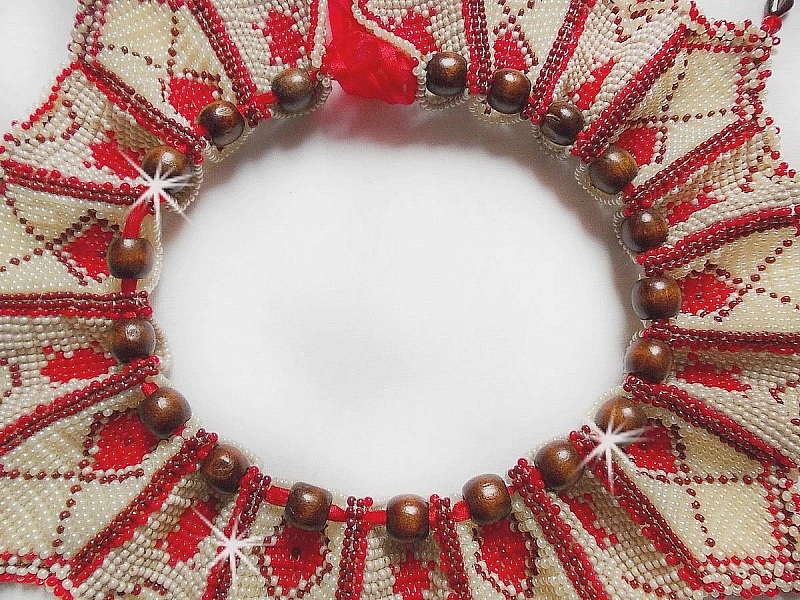 Collier Romane plastron mont&eacute; avec une abondance de rocailles aux couleurs : Bordeaux, Ivoire et Rouge &agrave; laquelle s'ajoute des gouttes plates, perles en bois, perles en laiton pour un style Ethnique