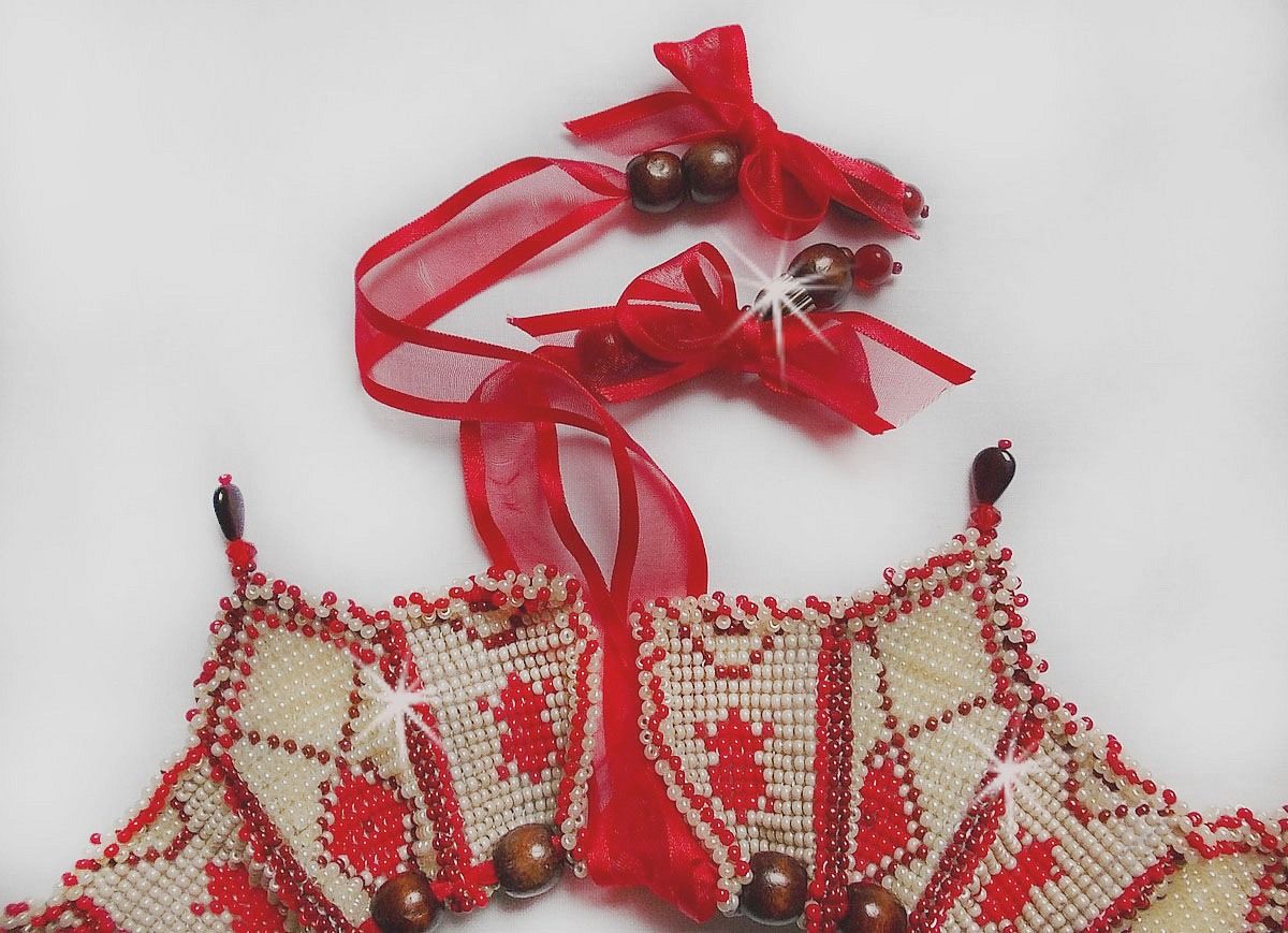 Collier Romane plastron mont&eacute; avec une abondance de rocailles aux couleurs : Bordeaux, Ivoire et Rouge &agrave; laquelle s'ajoute des gouttes plates, perles en bois, perles en laiton pour un style Ethnique