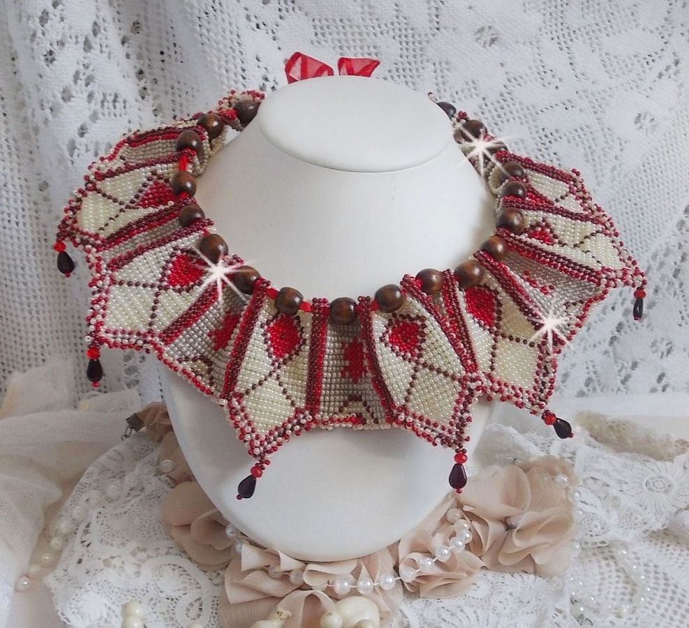 Collier Romane plastron mont&eacute; avec une abondance de rocailles aux couleurs : Bordeaux, Ivoire et Rouge &agrave; laquelle s'ajoute des gouttes plates, perles en bois, perles en laiton pour un style Ethnique