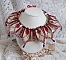 Collier Romane plastron mont&eacute; avec une abondance de rocailles aux couleurs : Bordeaux, Ivoire et Rouge &agrave; laquelle s'ajoute des gouttes plates, perles en bois, perles en laiton pour un style Ethnique