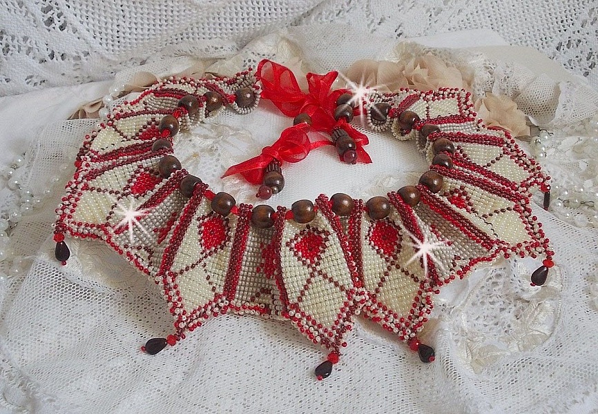 Collier Romane plastron mont&eacute; avec une abondance de rocailles aux couleurs : Bordeaux, Ivoire et Rouge &agrave; laquelle s'ajoute des gouttes plates, perles en bois, perles en laiton pour un style Ethnique