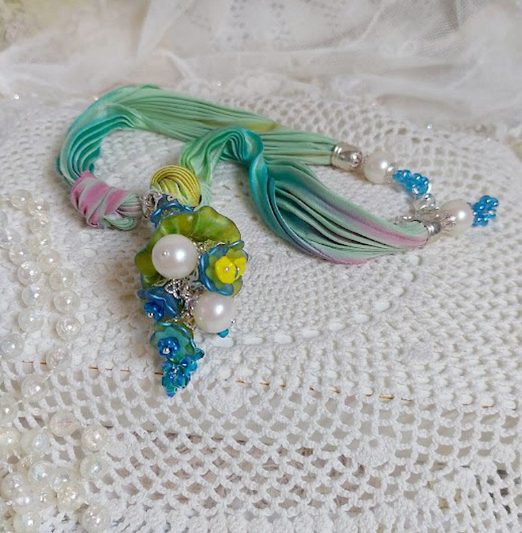 Collier artisanal en ruban de soie, fleurs acryliques et perles.