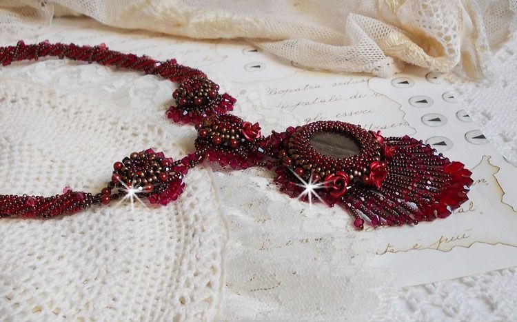 Collier Rubby One brod&eacute;  avec un cabochon en c&eacute;ramique de couleur Gris/Marron &agrave; laquelle s'ajoute des cabochons ronds en Cristal Siam, rocailles Bronze, toupies Light Rose et Rubby avec fermoir en T