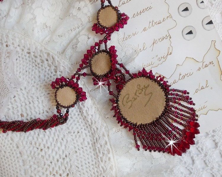 Collier Rubby One brod&eacute;  avec un cabochon en c&eacute;ramique de couleur Gris/Marron &agrave; laquelle s'ajoute des cabochons ronds en Cristal Siam, rocailles Bronze, toupies Light Rose et Rubby avec fermoir en T