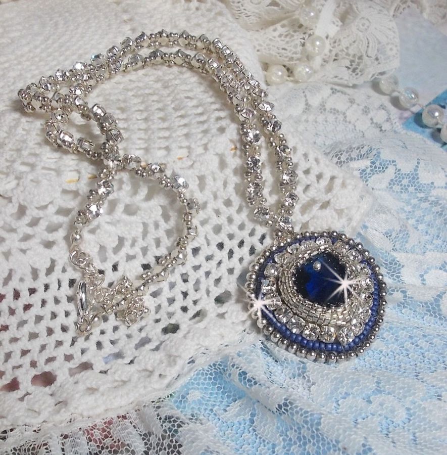 Collier Saphir Bleu brod&eacute; &agrave; l'aiguille avec un c&oelig;ur en cristal de Swarovski, rocailles argent&eacute;es Miyuki, strass, un fermoir et une cha&icirc;nette d'extension en argent 925/1000. Un voyage si lointain.