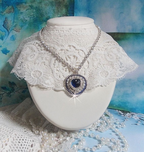 Collier Saphir Bleu brod&eacute; &agrave; l'aiguille avec un c&oelig;ur en cristal de Swarovski, rocailles argent&eacute;es Miyuki, strass, un fermoir et une cha&icirc;nette d'extension en argent 925/1000. Un voyage si lointain.