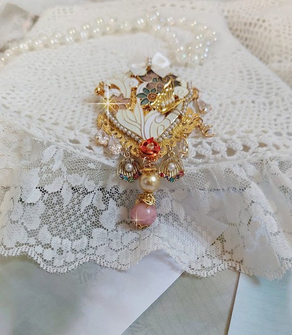 Pendentif Aurore mont&eacute; avec un motif &eacute;maill&eacute; aux couleurs du soleil &agrave; laquelle s&rsquo;ajoute perles nacr&eacute;es, breloques, poires avec Zircons, perles, ruban sur une b&eacute;li&egrave;re Argent 925 et une cha&icirc;ne plaqu&eacute; Or