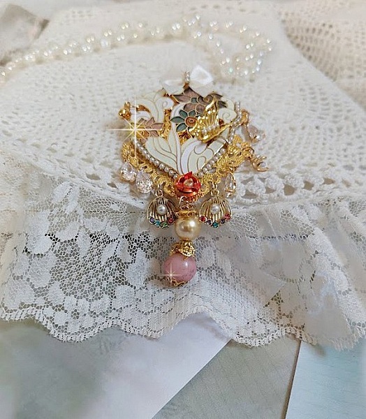Pendentif Aurore mont&eacute; avec un motif &eacute;maill&eacute; aux couleurs du soleil &agrave; laquelle s&rsquo;ajoute perles nacr&eacute;es, breloques, poires avec Zircons, perles, ruban sur une b&eacute;li&egrave;re Argent 925 et une cha&icirc;ne plaqu&eacute; Or