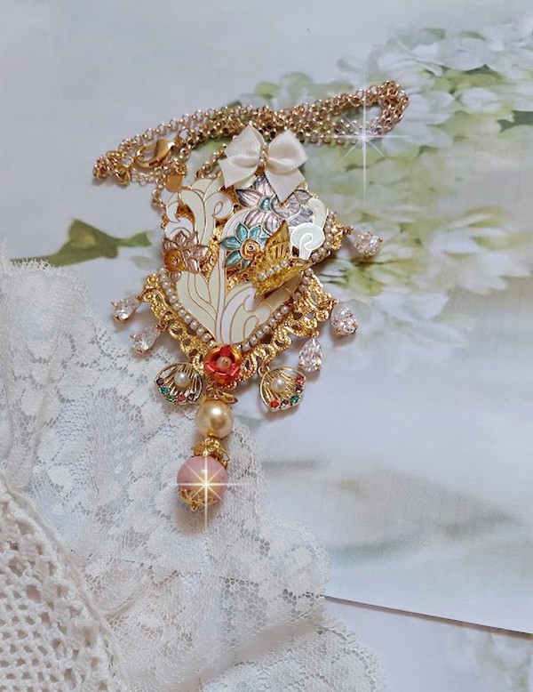 Pendentif Aurore mont&eacute; avec un motif &eacute;maill&eacute; aux couleurs du soleil &agrave; laquelle s&rsquo;ajoute perles nacr&eacute;es, breloques, poires avec Zircons, perles, ruban sur une b&eacute;li&egrave;re Argent 925 et une cha&icirc;ne plaqu&eacute; Or