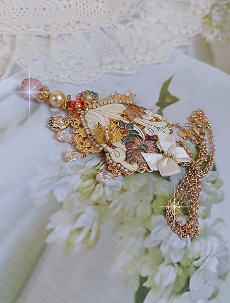 Pendentif Aurore mont&eacute; avec un motif &eacute;maill&eacute; aux couleurs du soleil &agrave; laquelle s&rsquo;ajoute perles nacr&eacute;es, breloques, poires avec Zircons, perles, ruban sur une b&eacute;li&egrave;re Argent 925 et une cha&icirc;ne plaqu&eacute; Or