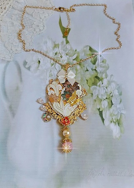 Pendentif Aurore mont&eacute; avec un motif &eacute;maill&eacute; aux couleurs du soleil &agrave; laquelle s&rsquo;ajoute perles nacr&eacute;es, breloques, poires avec Zircons, perles, ruban sur une b&eacute;li&egrave;re Argent 925 et une cha&icirc;ne plaqu&eacute; Or