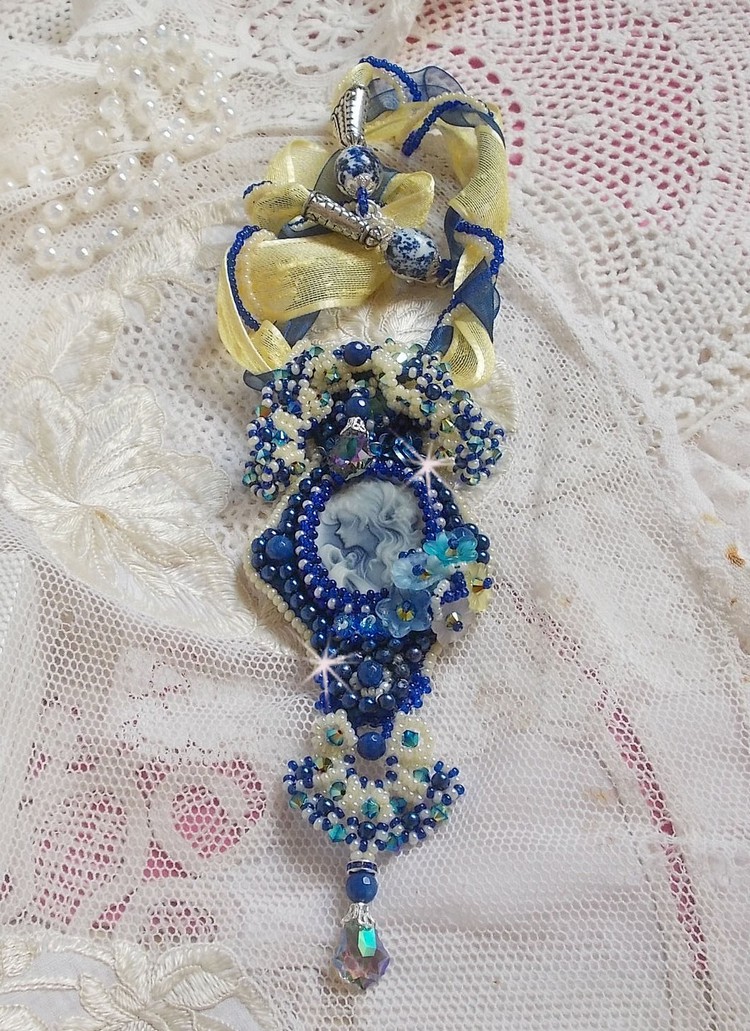 Pendentif haute couture brodé avec perles, cristaux et rubans bleus.
