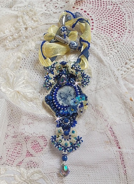 Pendentif haute couture brodé avec perles, cristaux et rubans bleus.