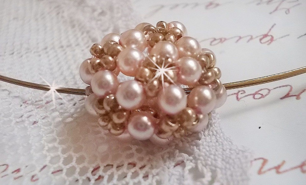 Pendentif Boules nacr&eacute;es avec des perles rondes en cristal de Swarovski de couleur P&ecirc;che et des rocailles en Verre Gold Bronze. Le tour du cou multi rangs est compos&eacute; de 3 rangs fil c&acirc;bl&eacute; en laiton.