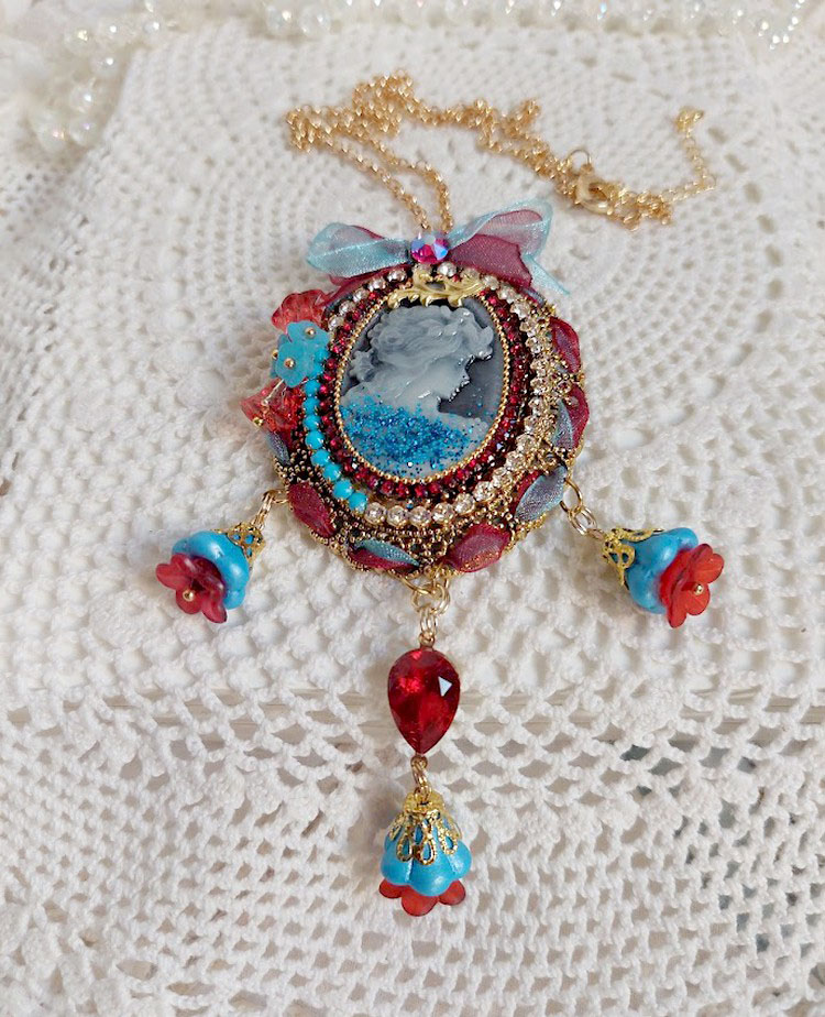 Pendentif broche Scarlet avec cabochon, perles et rubans colorés.