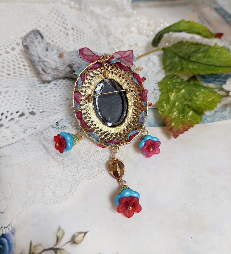 Dos d'un pendentif broche Scarlet avec perles et rubans.