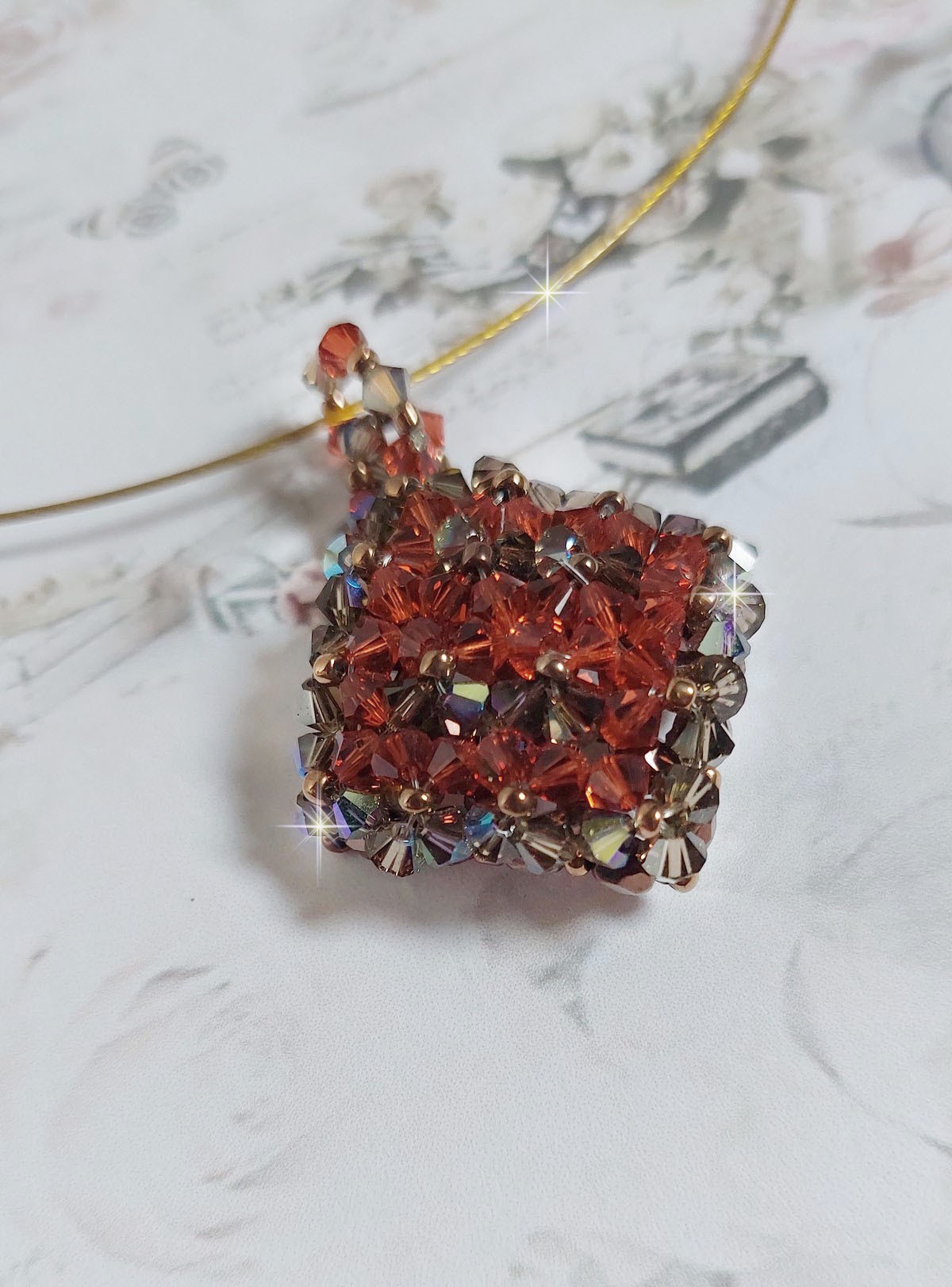 Pendentif Camel mont&eacute; avec des toupies en cristal Indian Red et Smoked Topaz de qualit&eacute; AB sur une base de facettes Dark Bronze et sur un tour de cou c&acirc;bl&eacute; rigide Dor&eacute; avec un fermoir &agrave; vis Argent&eacute;