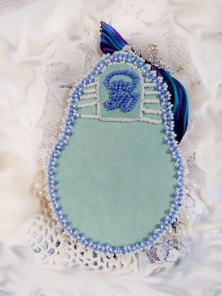 Pendentif brodé artisanal en forme de corne d'abondance bleue.