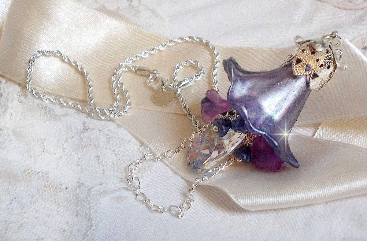 Pendentif Eclat de Cristal mont&eacute; avec une goutte en Cristal, fleurs en Verre, fleurs lucites dont une plus grande peinte &agrave; la main avec paillettes Argent&eacute;es. Une composition florale