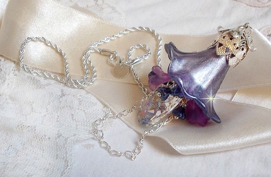 Pendentif Eclat de Cristal mont&eacute; avec une goutte en Cristal, fleurs en Verre, fleurs lucites dont une plus grande peinte &agrave; la main avec paillettes Argent&eacute;es. Une composition florale
