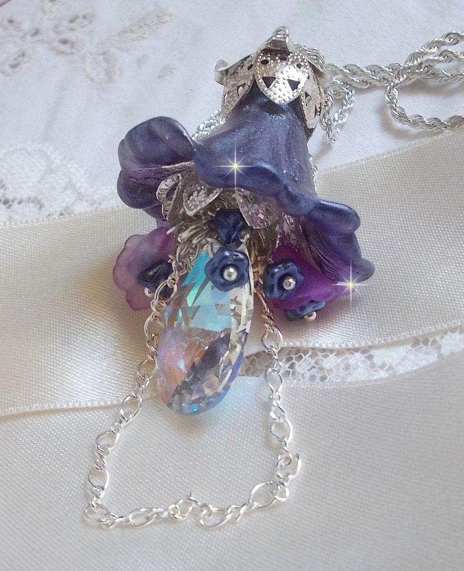 Pendentif Eclat de Cristal mont&eacute; avec une goutte en Cristal, fleurs en Verre, fleurs lucites dont une plus grande peinte &agrave; la main avec paillettes Argent&eacute;es. Une composition florale