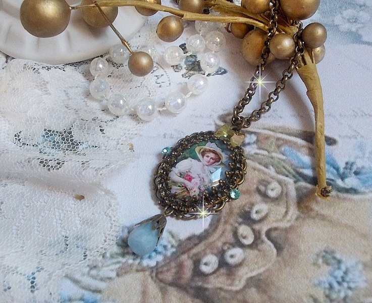Pendentif Douce Dame cr&eacute;&eacute; avec un cabochon repr&eacute;sentant une femme au chapeau blanc orn&eacute; de cristaux, des accessoires de couleur Bronze et un jade teint&eacute; bleu 