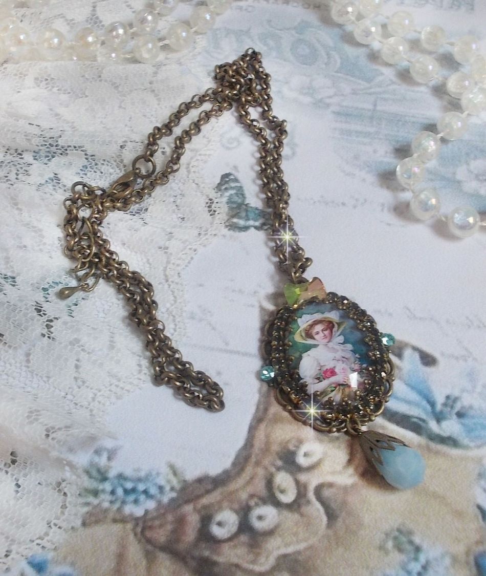 Pendentif Douce Dame cr&eacute;&eacute; avec un cabochon repr&eacute;sentant une femme au chapeau blanc orn&eacute; de cristaux, des accessoires de couleur Bronze et un jade teint&eacute; bleu 