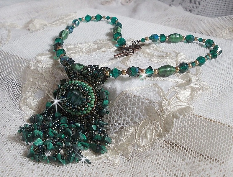 Pendentif Emerald avec un cabochon ovale en Malachite orn&eacute; de chips avec cristaux : perles rondes et toupies Emerald. S&rsquo;ajoute des perles en forme d&rsquo;olives. Brod&eacute;s sur fermoir en T. Un style Ethnique