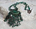 Pendentif Emerald avec un cabochon ovale en Malachite orn&eacute; de chips avec cristaux : perles rondes et toupies Emerald. S&rsquo;ajoute des perles en forme d&rsquo;olives. Brod&eacute;s sur fermoir en T. Un style Ethnique
