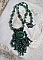 Pendentif Emerald avec un cabochon ovale en Malachite orn&eacute; de chips avec cristaux : perles rondes et toupies Emerald. S&rsquo;ajoute des perles en forme d&rsquo;olives. Brod&eacute;s sur fermoir en T. Un style Ethnique