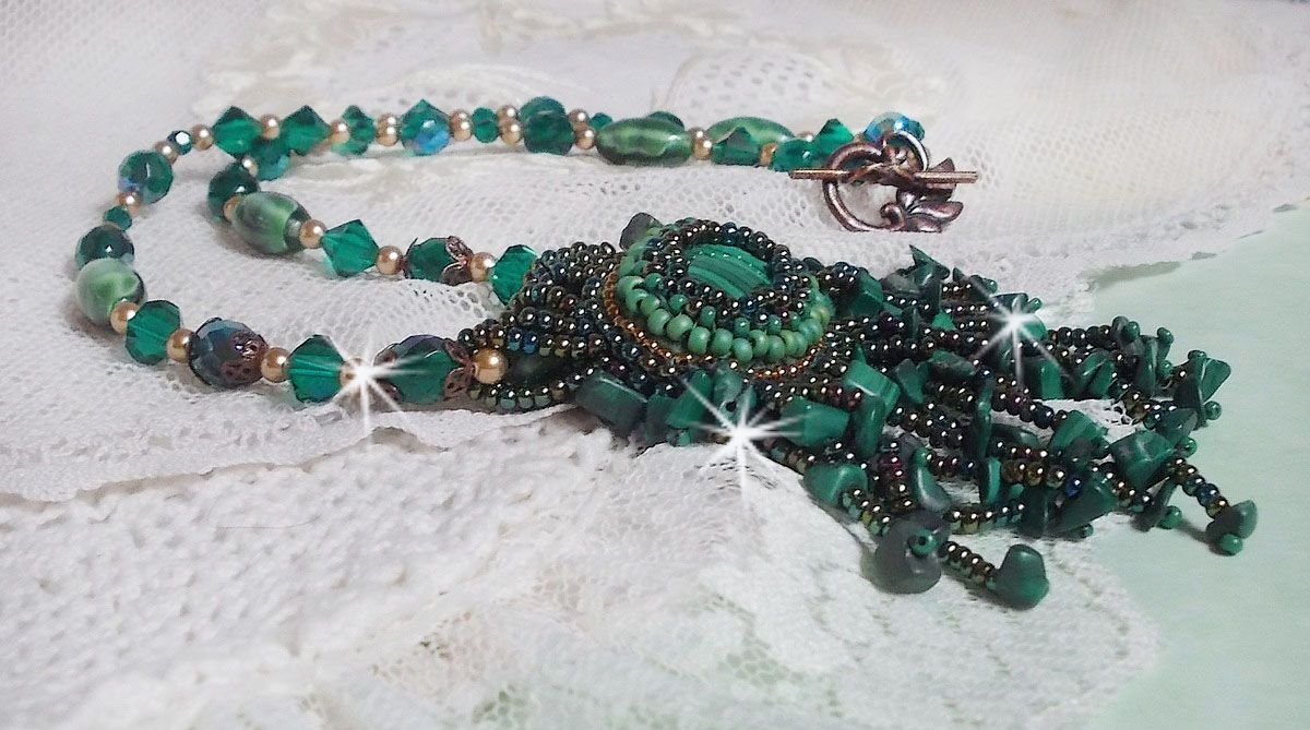 Pendentif Emerald avec un cabochon ovale en Malachite orn&eacute; de chips avec cristaux : perles rondes et toupies Emerald. S&rsquo;ajoute des perles en forme d&rsquo;olives. Brod&eacute;s sur fermoir en T. Un style Ethnique