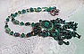 Pendentif Emerald avec un cabochon ovale en Malachite orn&eacute; de chips avec cristaux : perles rondes et toupies Emerald. S&rsquo;ajoute des perles en forme d&rsquo;olives. Brod&eacute;s sur fermoir en T. Un style Ethnique