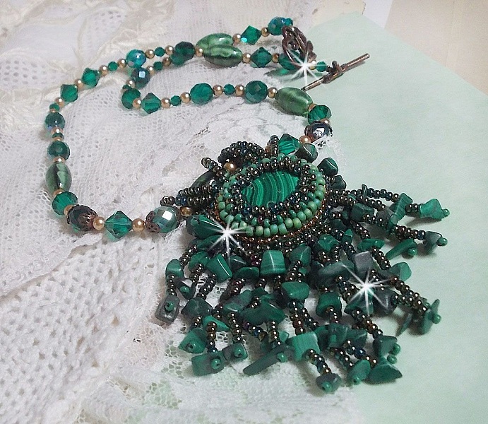 Pendentif Emerald avec un cabochon ovale en Malachite orn&eacute; de chips avec cristaux : perles rondes et toupies Emerald. S&rsquo;ajoute des perles en forme d&rsquo;olives. Brod&eacute;s sur fermoir en T. Un style Ethnique