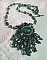 Pendentif Emerald avec un cabochon ovale en Malachite orn&eacute; de chips avec cristaux : perles rondes et toupies Emerald. S&rsquo;ajoute des perles en forme d&rsquo;olives. Brod&eacute;s sur fermoir en T. Un style Ethnique