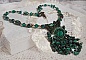 Pendentif Emerald avec un cabochon ovale en Malachite orn&eacute; de chips avec cristaux : perles rondes et toupies Emerald. S&rsquo;ajoute des perles en forme d&rsquo;olives. Brod&eacute;s sur fermoir en T. Un style Ethnique
