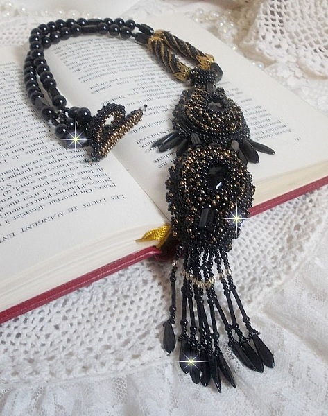 Pendentif Habit Noir pour un style Vintage est brod&eacute; avec une pierre de Gemme : l&rsquo;Onyx Noir &agrave; laquelle s&rsquo;ajoute des cristaux, dagues, perles, facettes et rocailles en Verre. Belle harmonie !