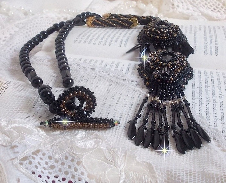Pendentif Habit Noir pour un style Vintage est brod&eacute; avec une pierre de Gemme : l&rsquo;Onyx Noir &agrave; laquelle s&rsquo;ajoute des cristaux, dagues, perles, facettes et rocailles en Verre. Belle harmonie !