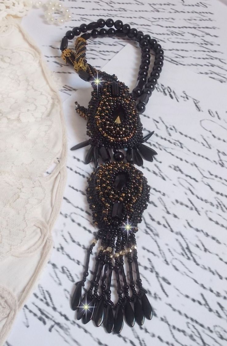 Pendentif Habit Noir pour un style Vintage est brod&eacute; avec une pierre de Gemme : l&rsquo;Onyx Noir &agrave; laquelle s&rsquo;ajoute des cristaux, dagues, perles, facettes et rocailles en Verre. Belle harmonie !