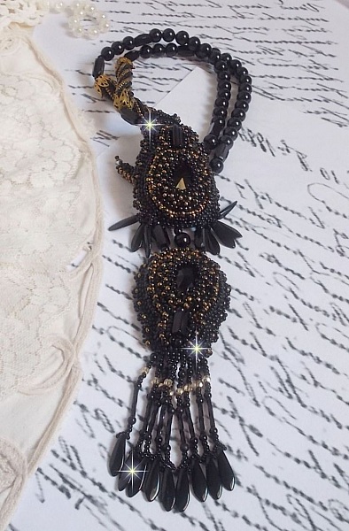 Pendentif Habit Noir pour un style Vintage est brod&eacute; avec une pierre de Gemme : l&rsquo;Onyx Noir &agrave; laquelle s&rsquo;ajoute des cristaux, dagues, perles, facettes et rocailles en Verre. Belle harmonie !
