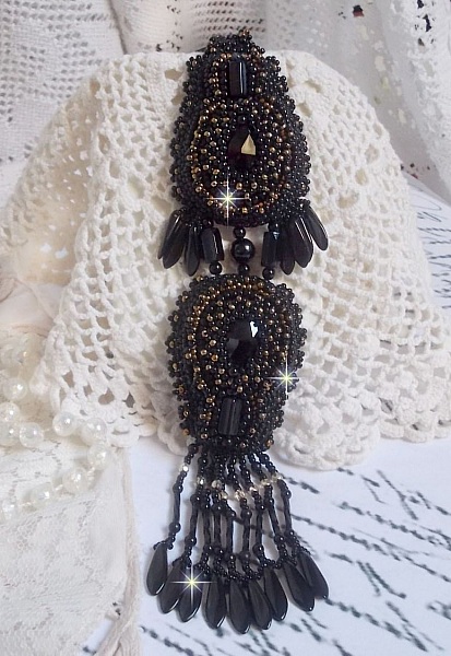 Pendentif Habit Noir pour un style Vintage est brod&eacute; avec une pierre de Gemme : l&rsquo;Onyx Noir &agrave; laquelle s&rsquo;ajoute des cristaux, dagues, perles, facettes et rocailles en Verre. Belle harmonie !