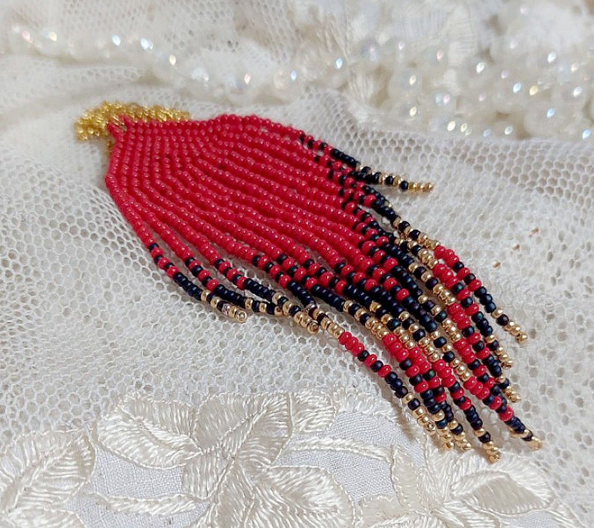 Pendentif Tourbillons de Rouge avec des rocailles aux trois couleurs : Rouge, Bleu Iris et Dor&eacute; pour les pampilles. Le tout est mont&eacute; sur une cha&icirc;ne et un mousqueton en Plaqu&eacute; Or
