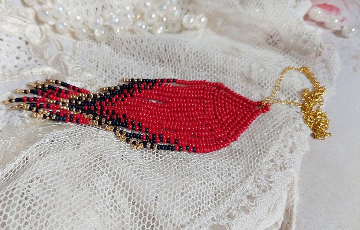 Pendentif Tourbillons de Rouge avec des rocailles aux trois couleurs : Rouge, Bleu Iris et Dor&eacute; pour les pampilles. Le tout est mont&eacute; sur une cha&icirc;ne et un mousqueton en Plaqu&eacute; Or