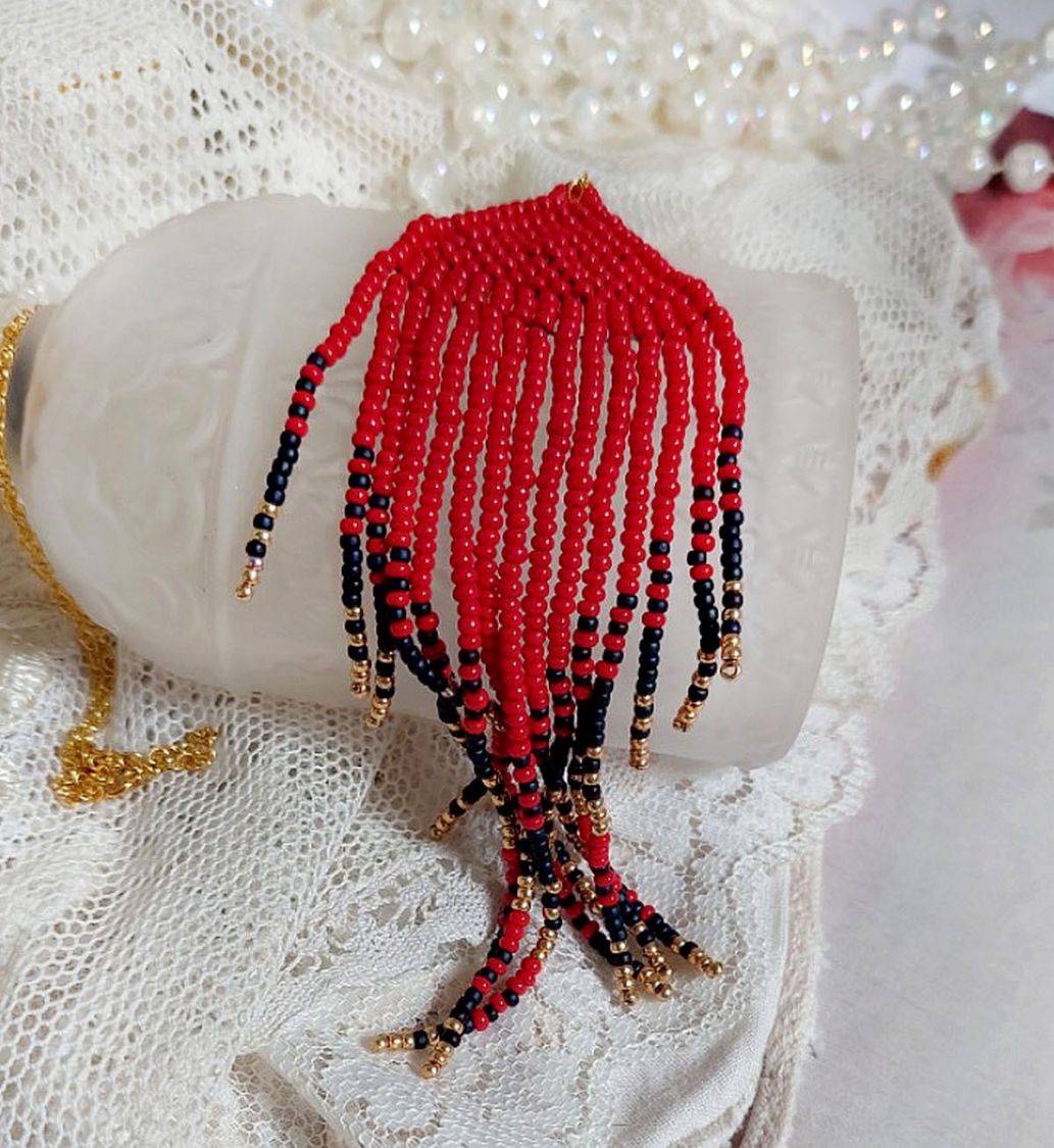 Pendentif Tourbillons de Rouge avec des rocailles aux trois couleurs : Rouge, Bleu Iris et Dor&eacute; pour les pampilles. Le tout est mont&eacute; sur une cha&icirc;ne et un mousqueton en Plaqu&eacute; Or